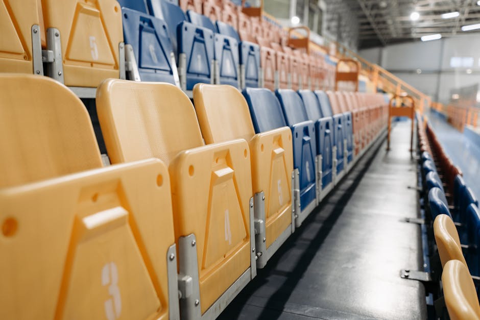 Close-up of colorful numbered seats in a modern indoor sports venue, awaiting spectators.